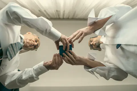 Several hands holding the rings up during the ceremony