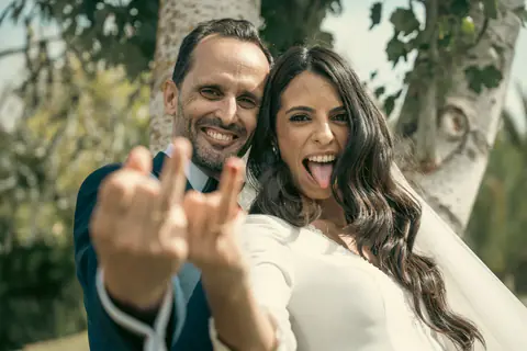 The couple showing their rings to the camera, laughing