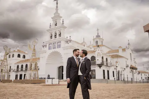The couple in front of the El Rocío hermitage in Almonte (Huelva), under a stormy sky